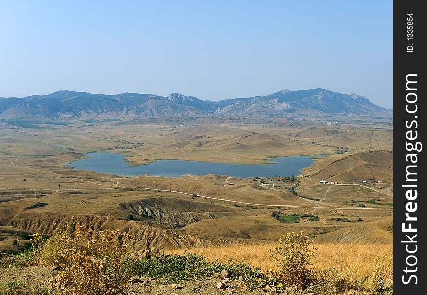 Lake in valley, far mountains