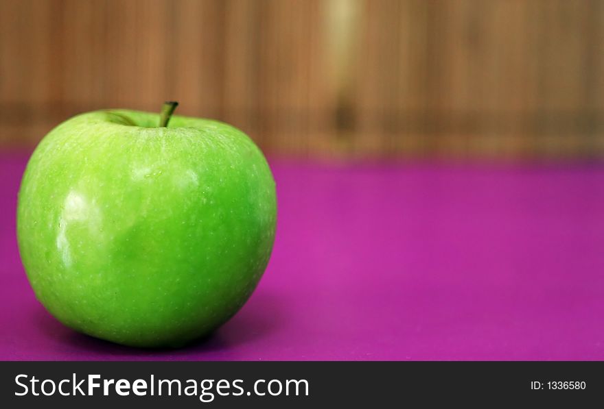 Green apple on pink background