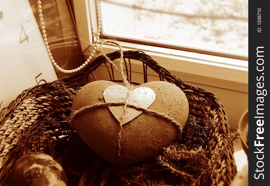 Still-life with earthenware heart in basket and clock. Still-life with earthenware heart in basket and clock