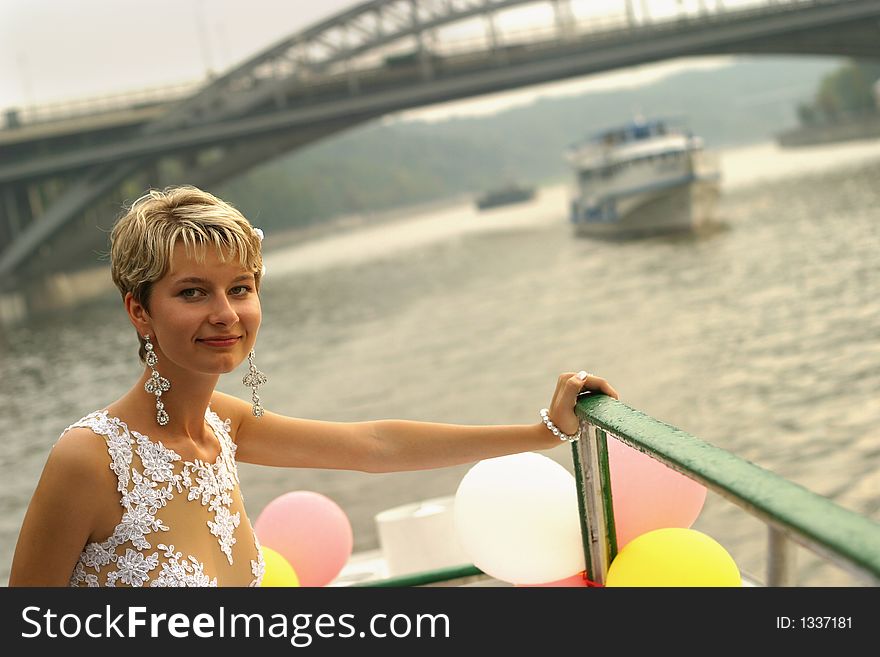 Smiling bride stands by the steam-ship