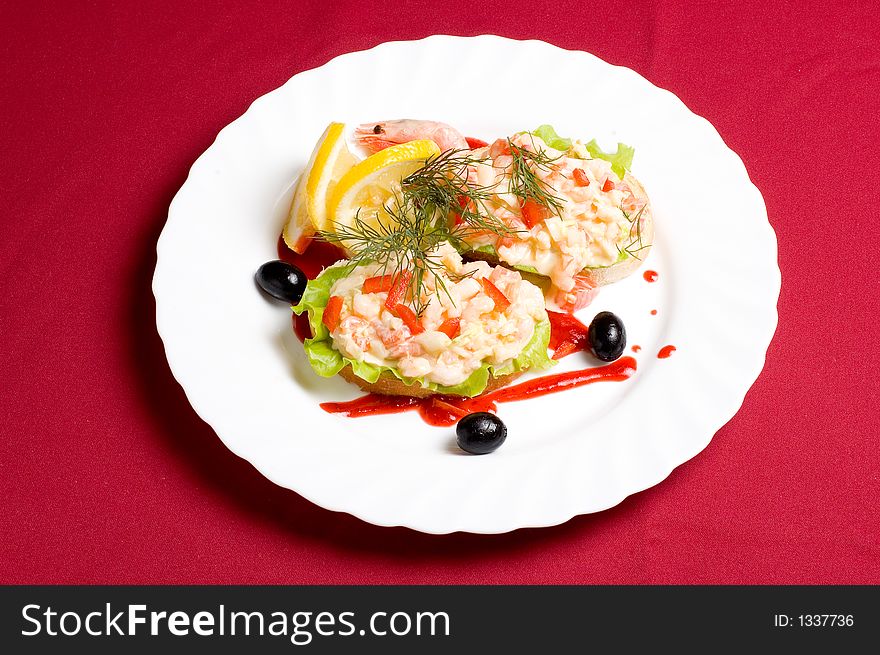 Slices of white-bread with shrimp salad and paprika decorated with olives lemon and strawberry jam. Slices of white-bread with shrimp salad and paprika decorated with olives lemon and strawberry jam