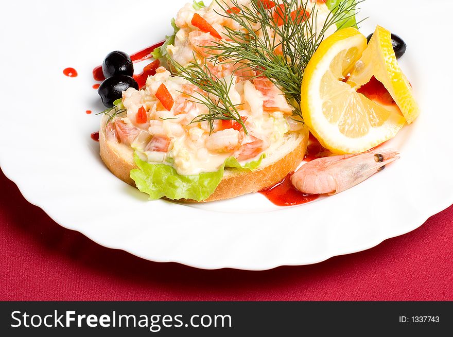 Slices of white-bread with shrimp salad and paprika decorated with olives lemon and strawberry jam. Slices of white-bread with shrimp salad and paprika decorated with olives lemon and strawberry jam