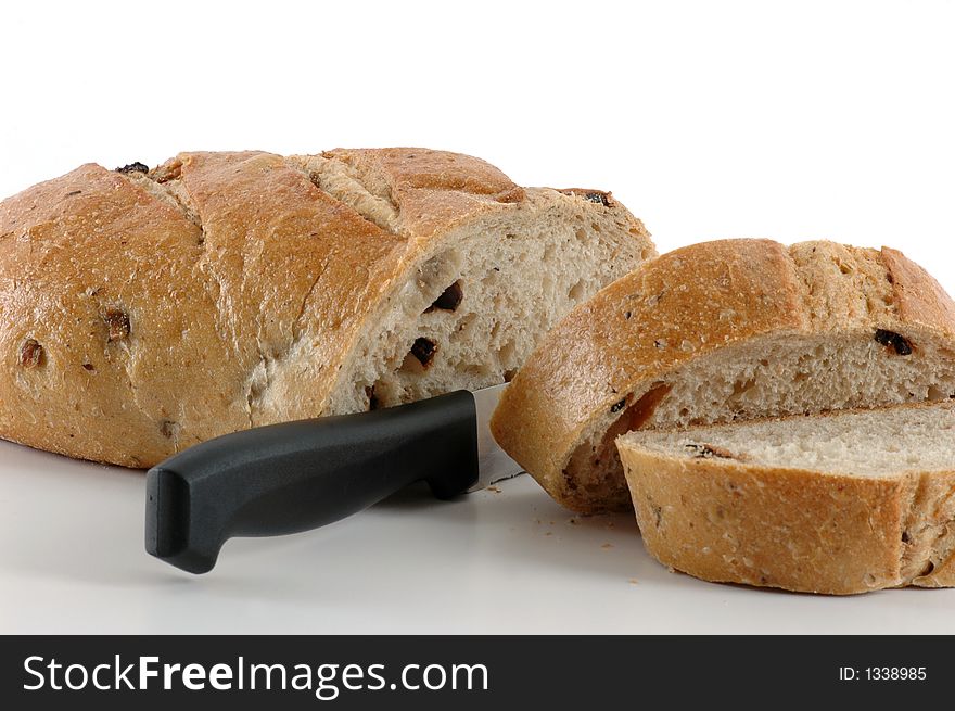 Slicing hearty pieces of fresh baked olive loaf. Slicing hearty pieces of fresh baked olive loaf.