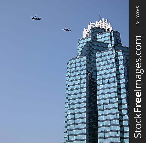 Blue office tower against sky with helicopters. Blue office tower against sky with helicopters
