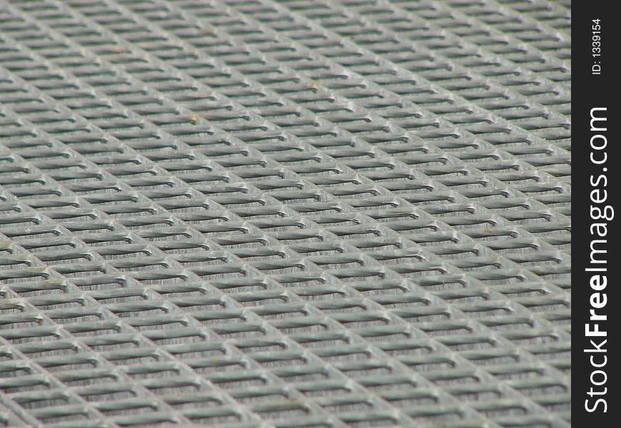 Photo of metal grid in factory used as cover of canal