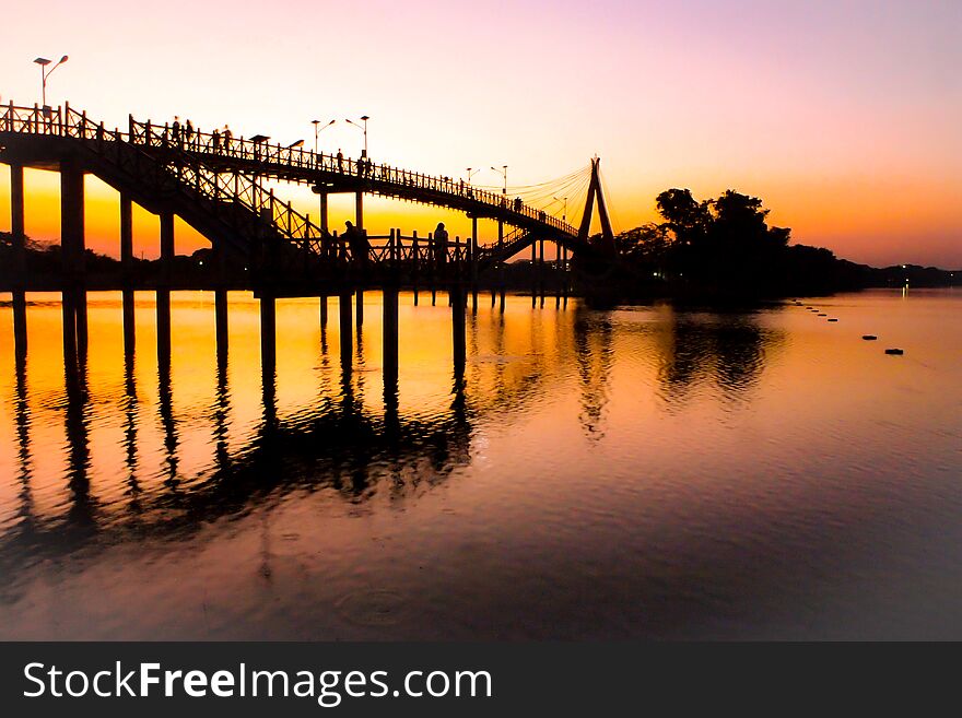People silhouettes watching colorful sunset bridge sunset river bridge people silhouette admire wallpaper Silhouettes of people walking across the iconic bridge over River at sunset