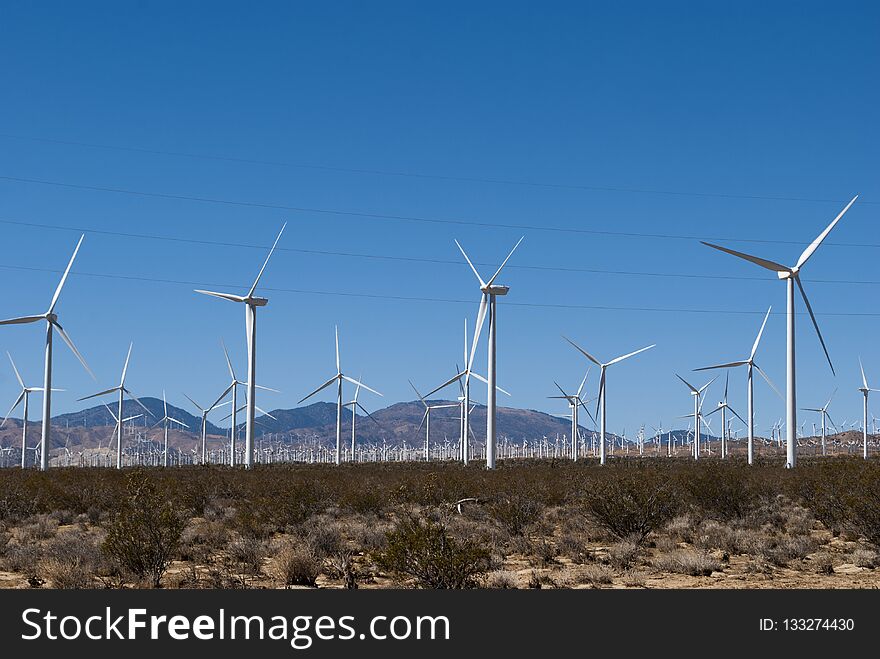 Wind mills working on hills with blue sky on background