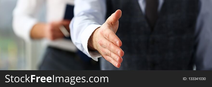 Man in suit and tie give hand as hello in office closeup. Friend welcome mediation offer positive introduction thanks gesture summit participate executive approval motivation male arm strike bargain.