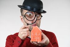 Man Magnifying Red House Stock Image