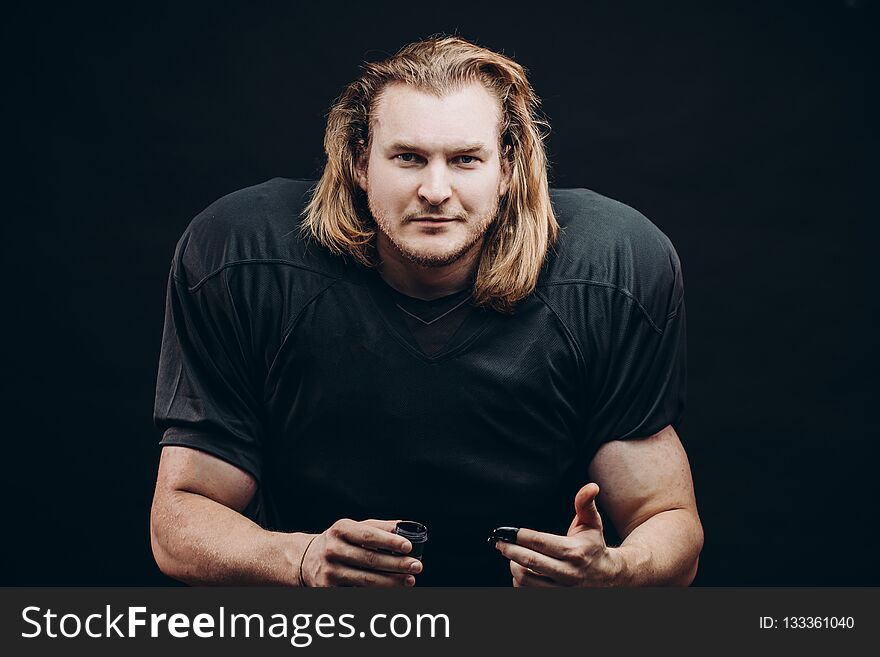 Determined American Football Player In Action Isolated On Black Background