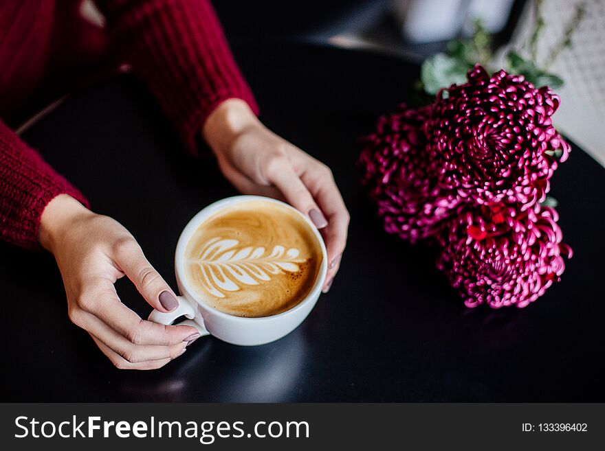 Close up of beautiful female hand holding big white cup of cappuccino coffee. Close up of beautiful female hand holding big white cup of cappuccino coffee.