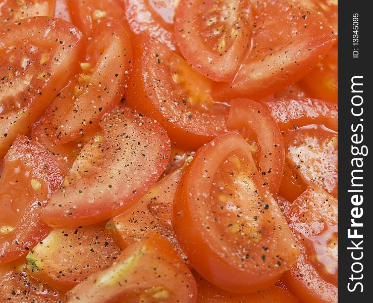 Sliced tomatos with salt and pepper background