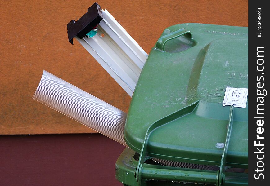 Green Plastic Recycling Bin With Recycled Items Sticking Out