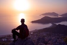 Traveler Relaxes On A Cliff And Admires The Amazing Sea Bay Royalty Free Stock Photo