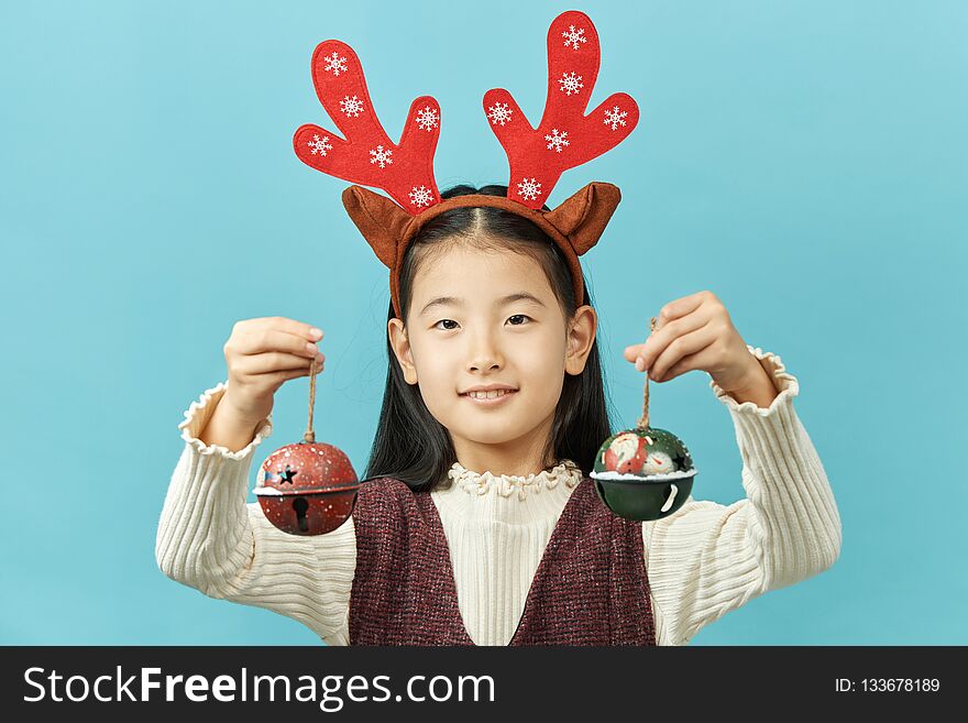 Asian girl with a Christmas concept headdress Child, Close up of cute little asian girl on blue background isolated