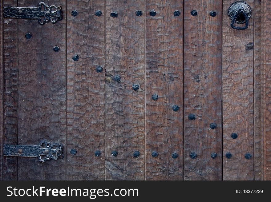 Old wooden door with metal knob and nails