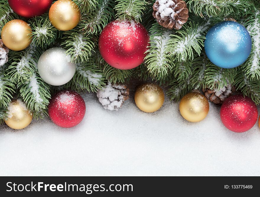 Christmas tree decoration with colored balls under snow as frame