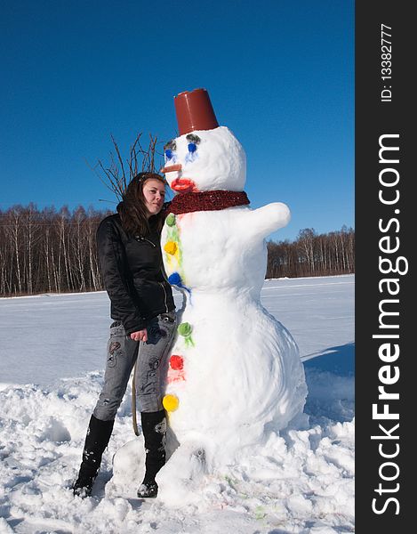 The girl embraces the snowman thawing on the sun. The girl embraces the snowman thawing on the sun