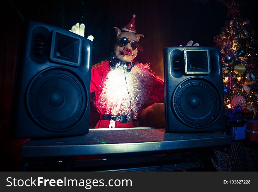 Dj Santa Claus at Christmas with glasses and snow mix on New Year's Eve event in the rays of light