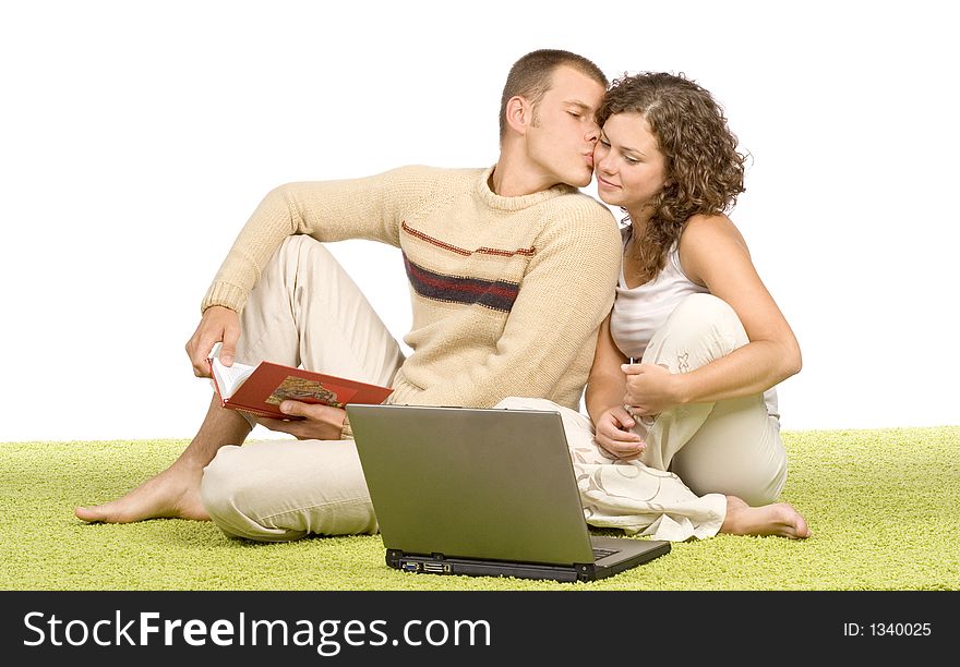 Isolated on white young couple on green carpet with laptop and book