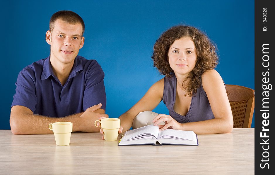 Young Couple At The Table With Book