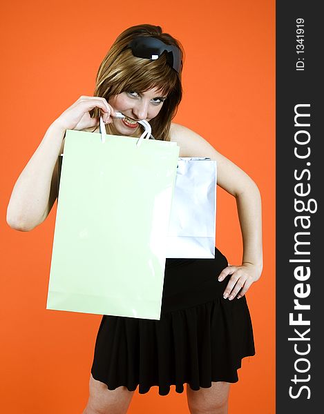 Brown haired young woman holds some shopping bags and a debit card - shopping addiction. Brown haired young woman holds some shopping bags and a debit card - shopping addiction