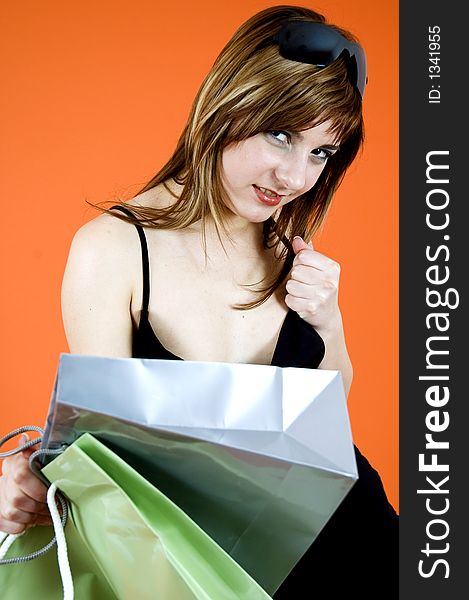 Brown haired young woman holds some shopping bags and a debit card - shopping addiction. Brown haired young woman holds some shopping bags and a debit card - shopping addiction