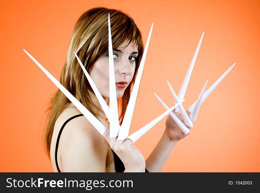 Funny looking cute girl poses with scissor fingers made out of paper - Freddy Kruger style