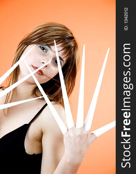 Funny looking cute girl poses with scissor fingers made out of paper - Freddy Kruger style