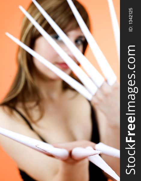 Funny looking cute girl poses with scissor fingers made out of paper - Freddy Kruger style