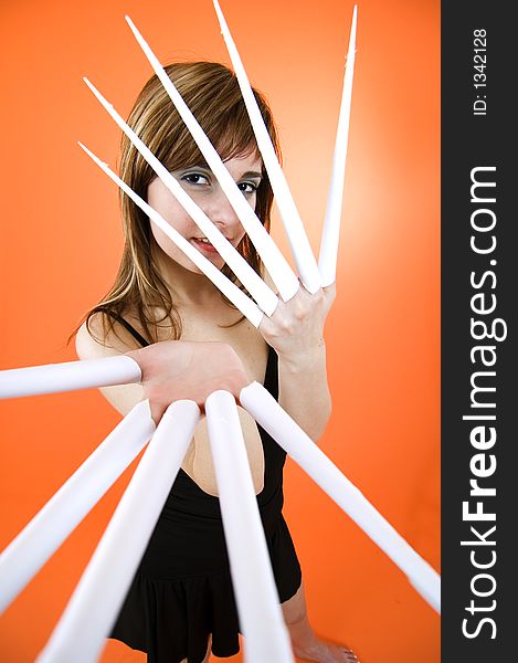 Funny looking cute girl poses with scissor fingers made out of paper - Freddy Kruger style