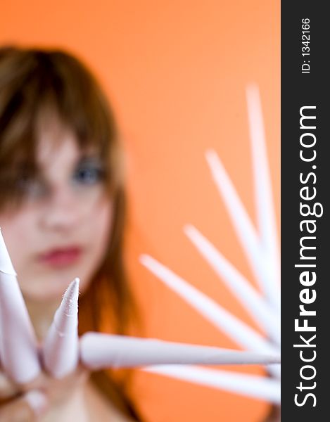 Funny looking cute girl poses with scissor fingers made out of paper - Freddy Kruger style