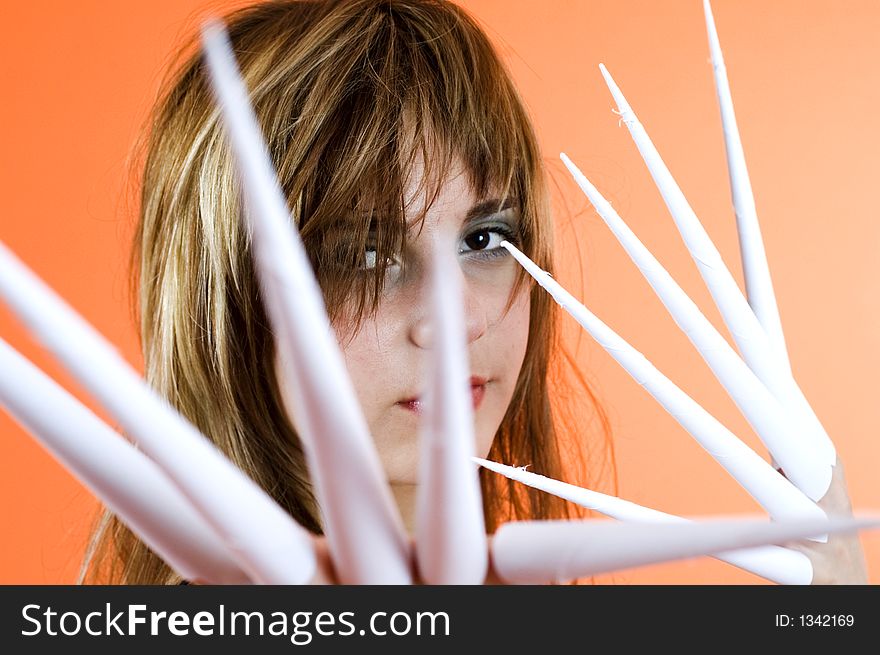 Funny looking cute girl poses with scissor fingers made out of paper - Freddy Kruger style