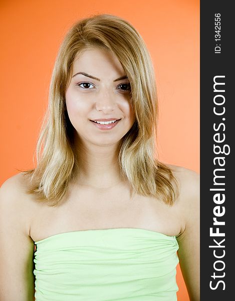 Portrait of a beautiful young blond smiling; orange background. Portrait of a beautiful young blond smiling; orange background