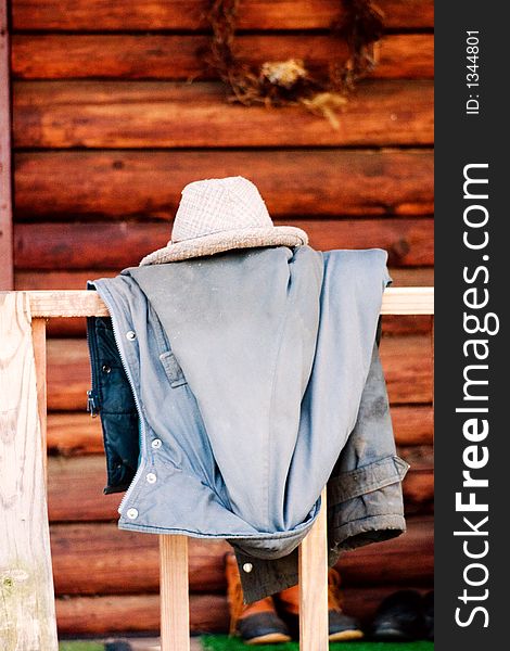 An old hat and coat thrown on the railing of a log cabin in Upstate New York