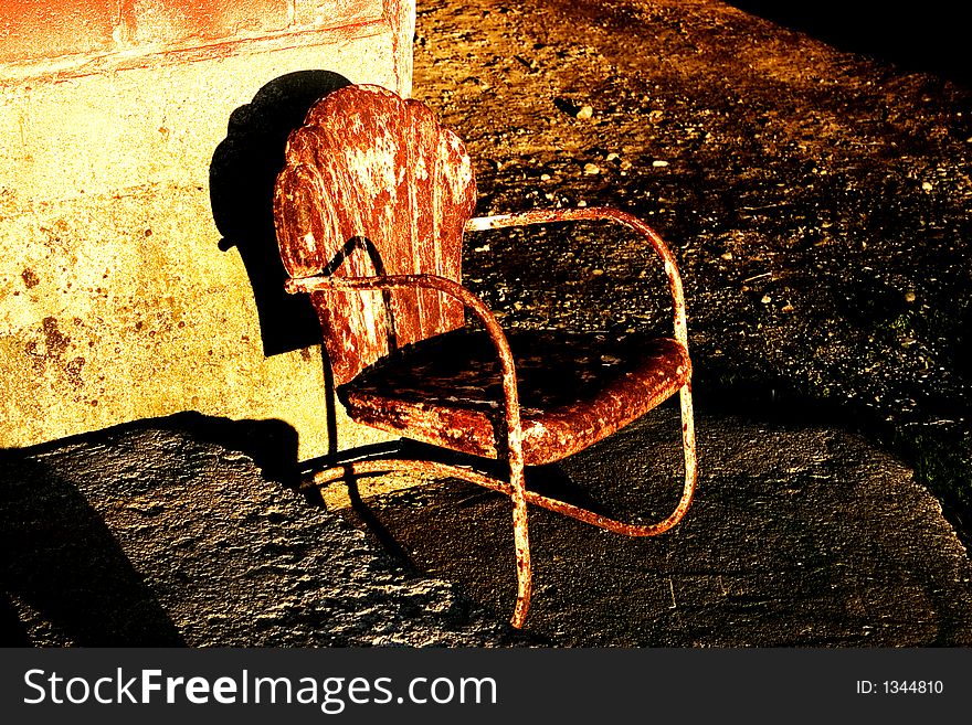 Old rusty metal chair shot outside a barn. Old rusty metal chair shot outside a barn