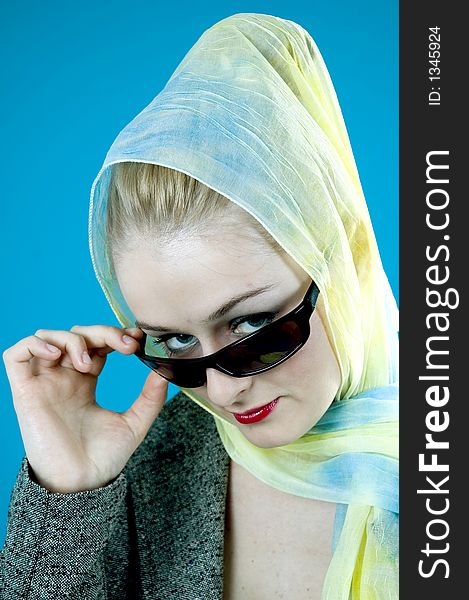 Blond model with light blue and yellow scarf and black sunglasses, poses with a condescending, sixties diva-like expression, holding a cigarette. Blond model with light blue and yellow scarf and black sunglasses, poses with a condescending, sixties diva-like expression, holding a cigarette