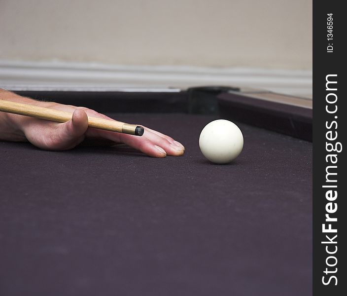 Pool player cueing up to strike cue ball. Pool player cueing up to strike cue ball.