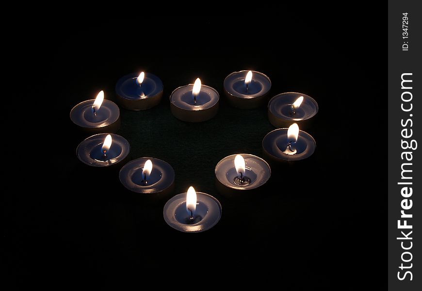 Herta of small candles over black. Herta of small candles over black