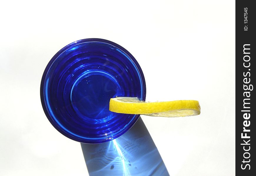 Cocktail drink decorated with lemon and served in a blue glass. Cocktail drink decorated with lemon and served in a blue glass