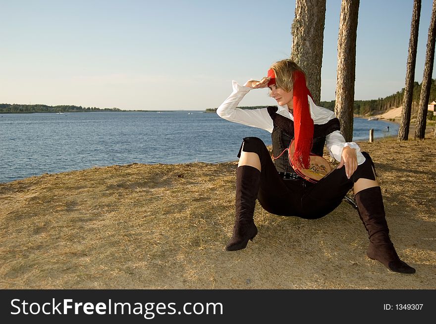 Pirate girl waiting for her ship on a beach