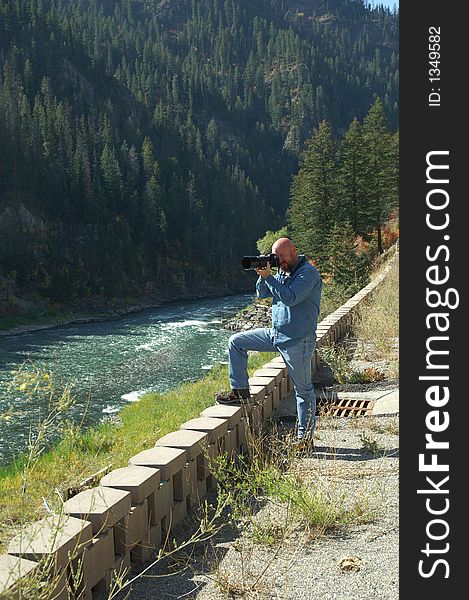 Male Photographer takes a photo along the river