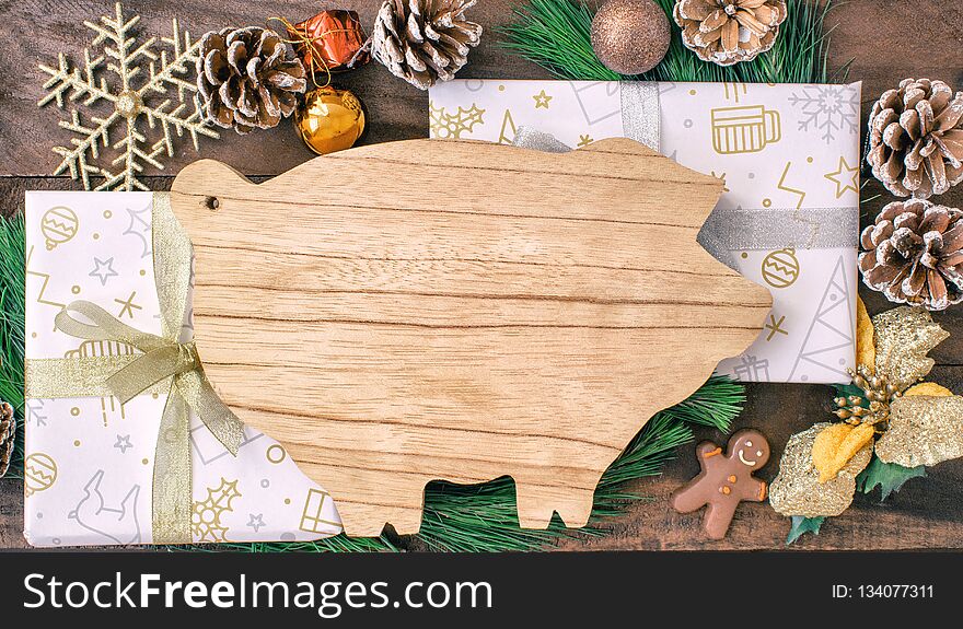 Christmas preparations, cutting board in the form of pigs, fir branches, cones and decorations. New Year of the pig on the Chinese calendar.