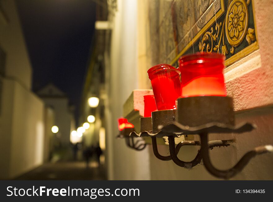 Red candles attached to little street altar at night, Capuchins Square, Cordoba, Andalusia, Spain. Red candles attached to little street altar at night, Capuchins Square, Cordoba, Andalusia, Spain