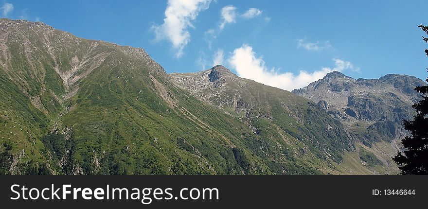 Wide panoramic of mountains with blue sky above. Wide panoramic of mountains with blue sky above