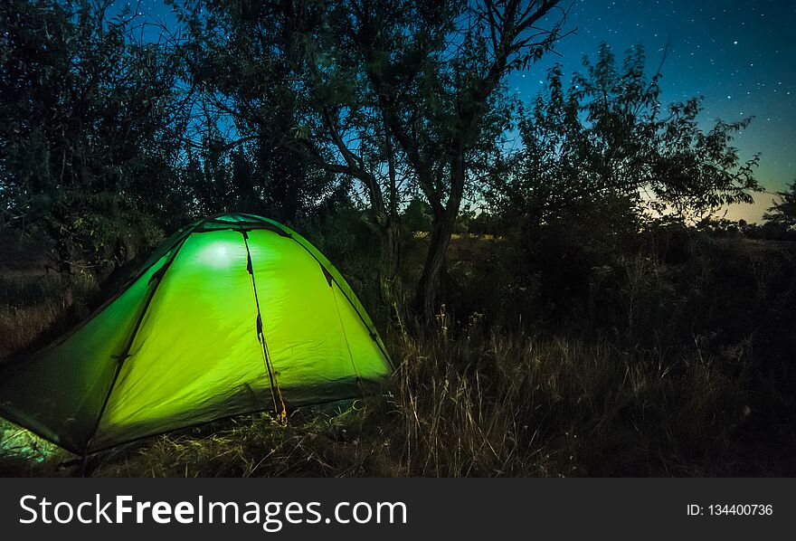 Bright tourist tent under starry sky