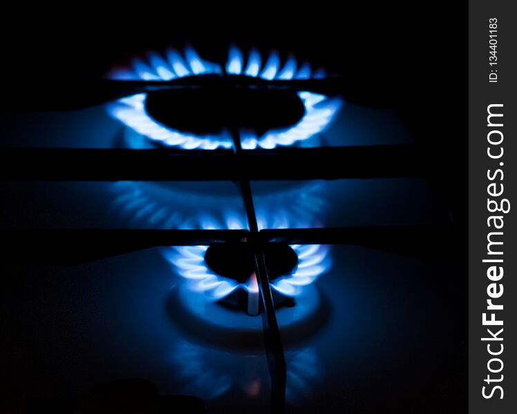 Gas burner with burning blue flame in the dark room. Gas burner with burning blue flame in the dark room