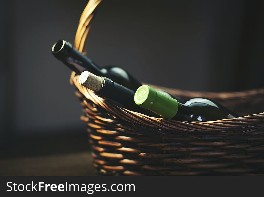 Wine bottles in basket on black background. Wine bottles in basket on black background