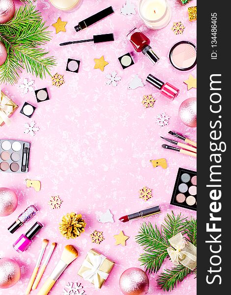 Make up cosmetics, presents and Christmas decorations on artistic pink background, copy space