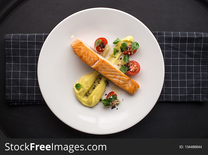 Grilled Salmon Fillets With Potato Mash And Tomatoes On Stone Board On Black Background